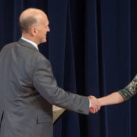 Woman smiling and shaking hands with Dean Potteiger as she receives her award
